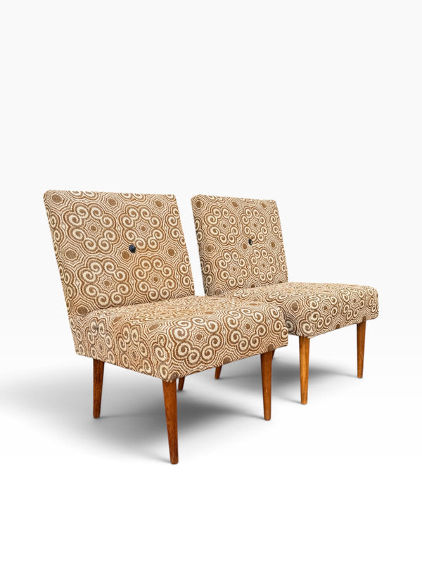 Pair of retro slipper chairs on tapered wooden legs, three-quarter view