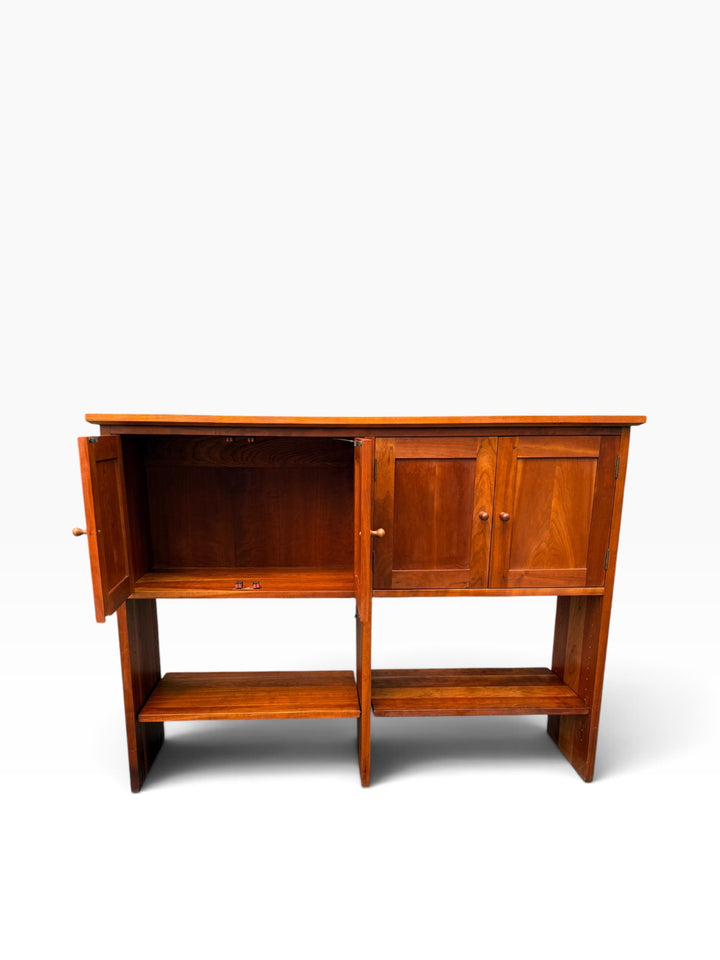 Left cabinet bay open showing adjustable cherry shelf