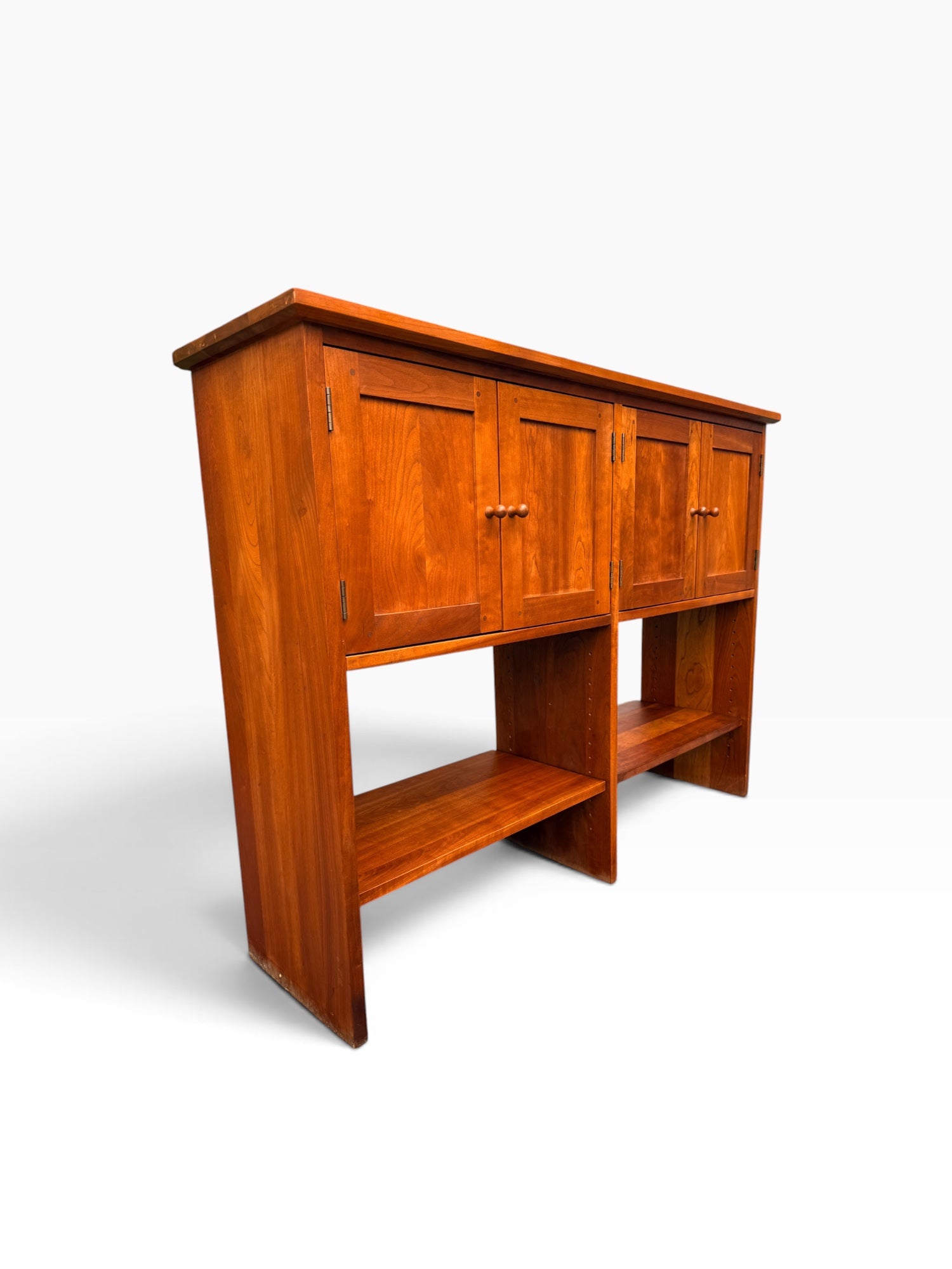 Open lower display shelves on cherry console table