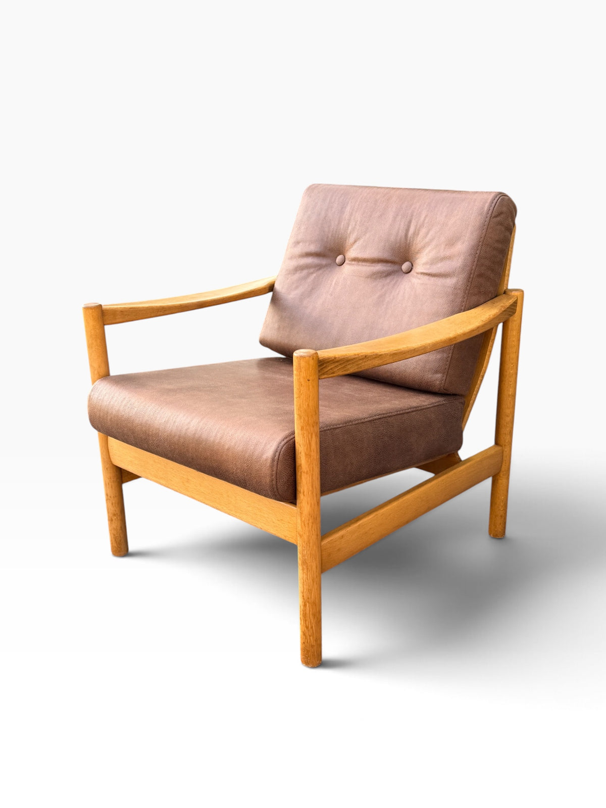 Danish lounge chair with sculpted wood armrests, three-quarter view