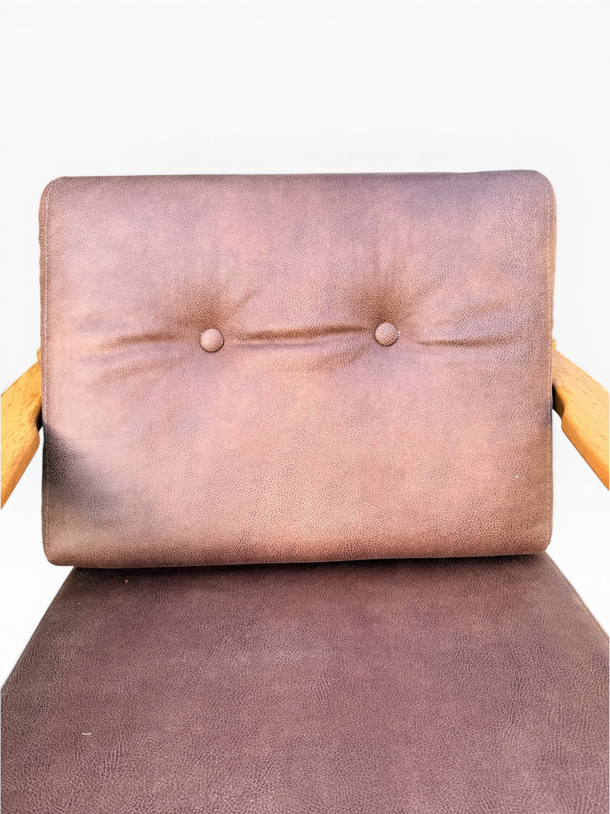 Close-up of button-tufted brown leather back cushion