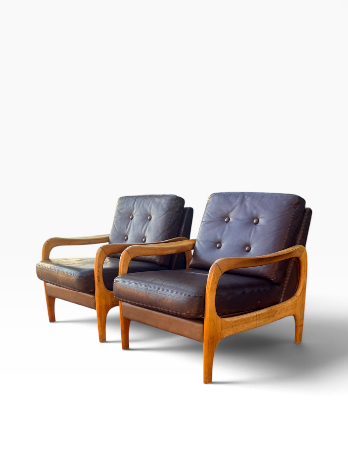 Pair of mid-century leather armchairs, three-quarter view