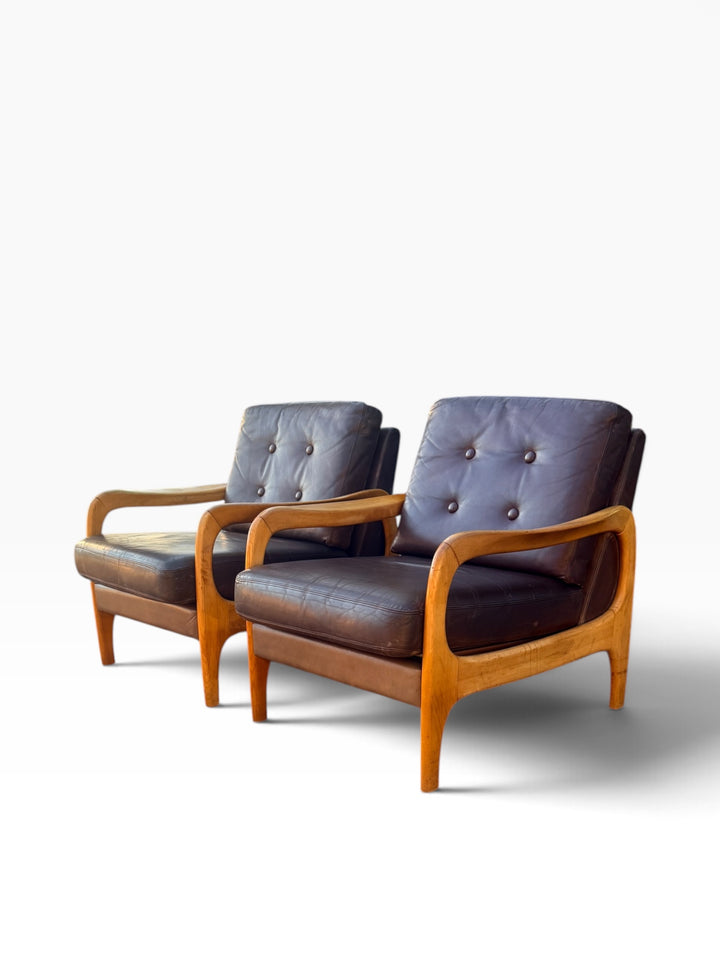 Pair of mid-century leather armchairs, three-quarter view