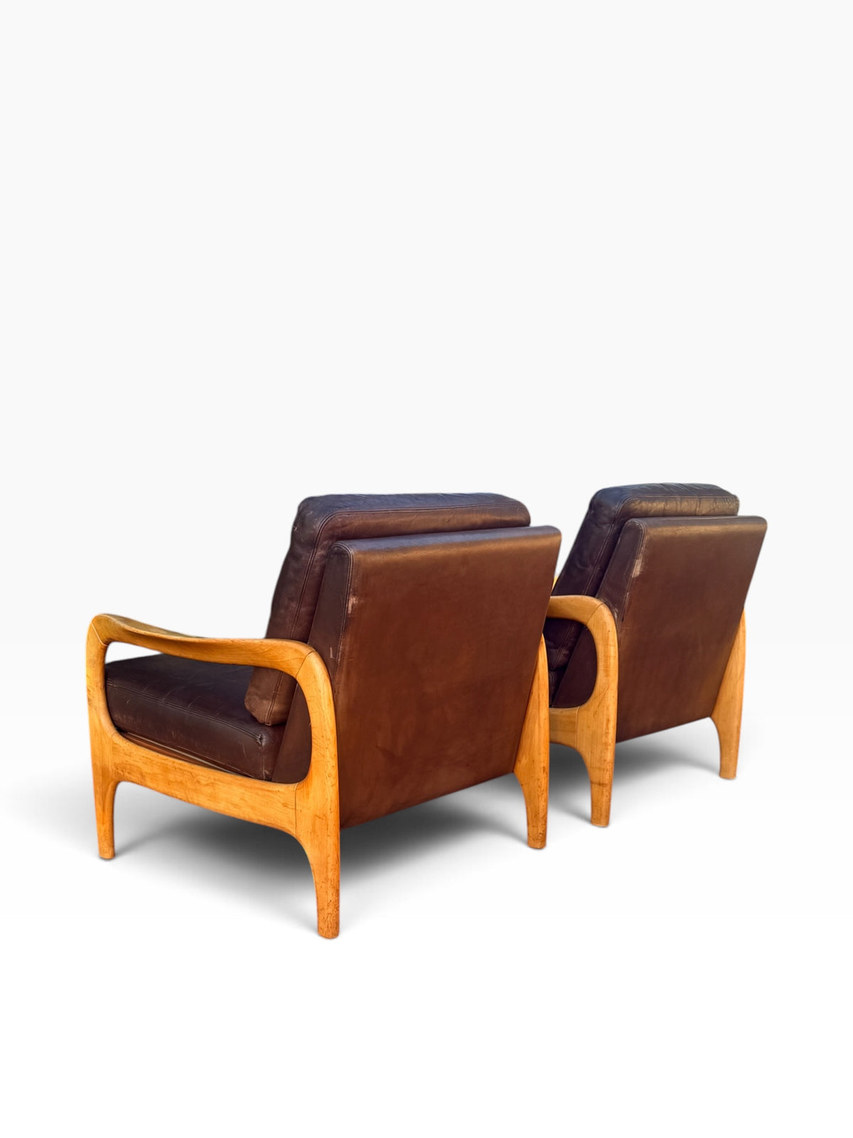 Rear three-quarter view of pair of leather lounge chairs