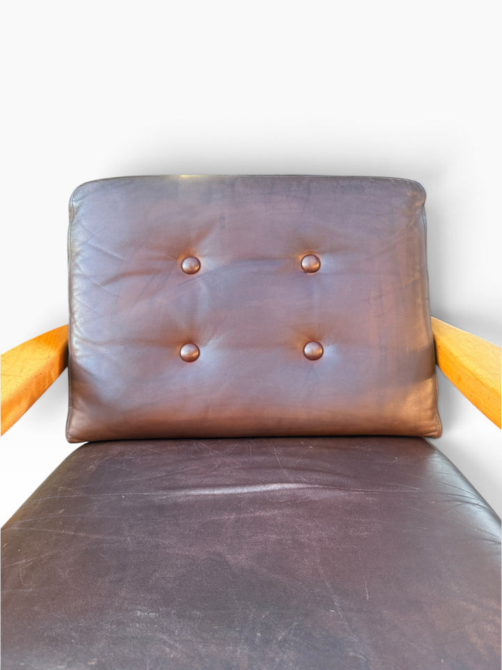 Close-up of button-tufted brown leather back cushion