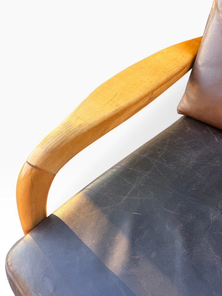 Maple arm detail with worn brown leather seat
