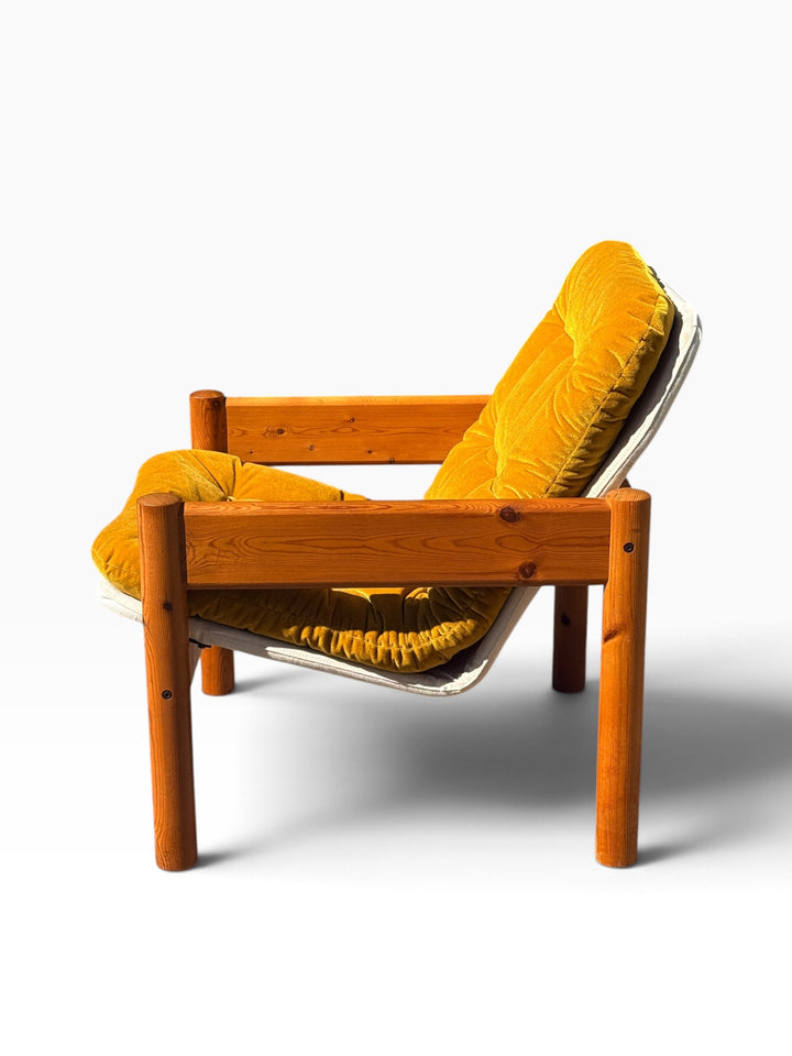Side profile showing the broad pine arm rail and round post legs