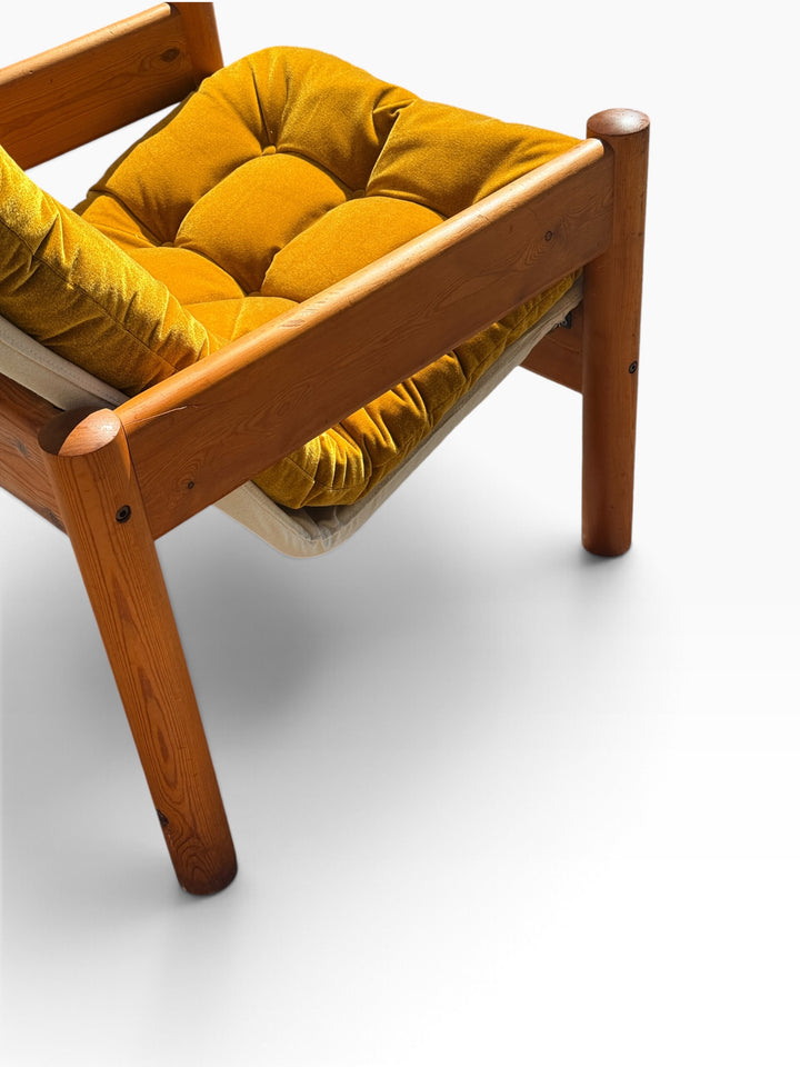 Close detail of the tufted mustard velvet seat cushion and pine frame