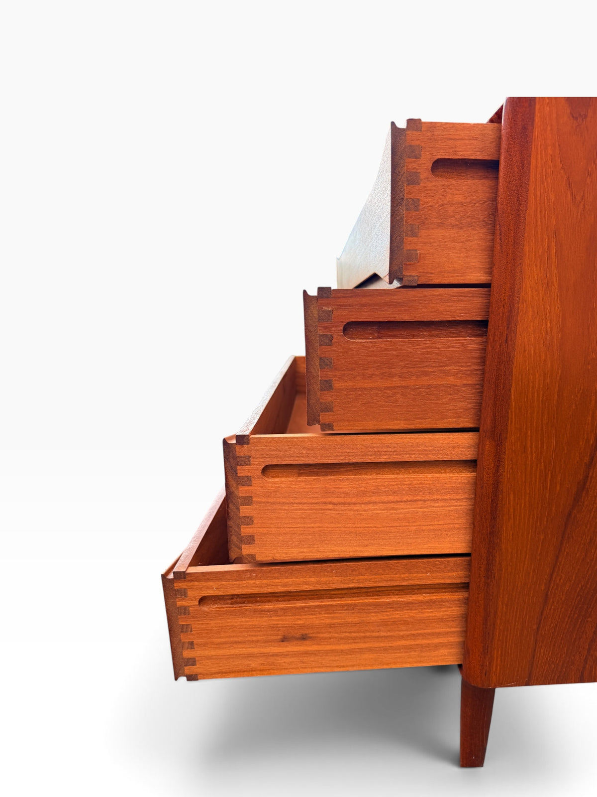 Close-up of hand-cut dovetail joinery on a teak drawer