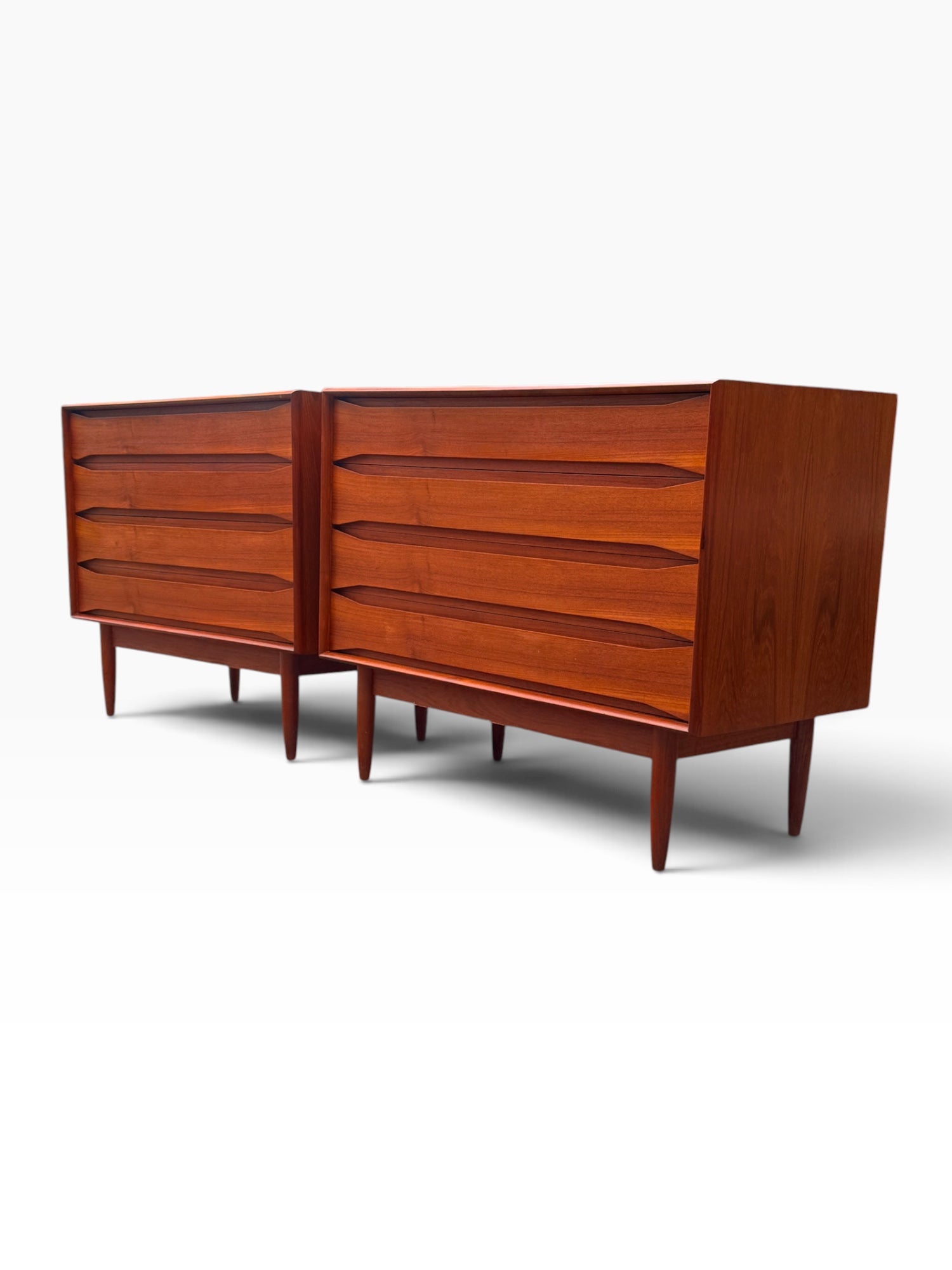Pair of Danish modern teak dressers, three-quarter angle showing sculpted pulls