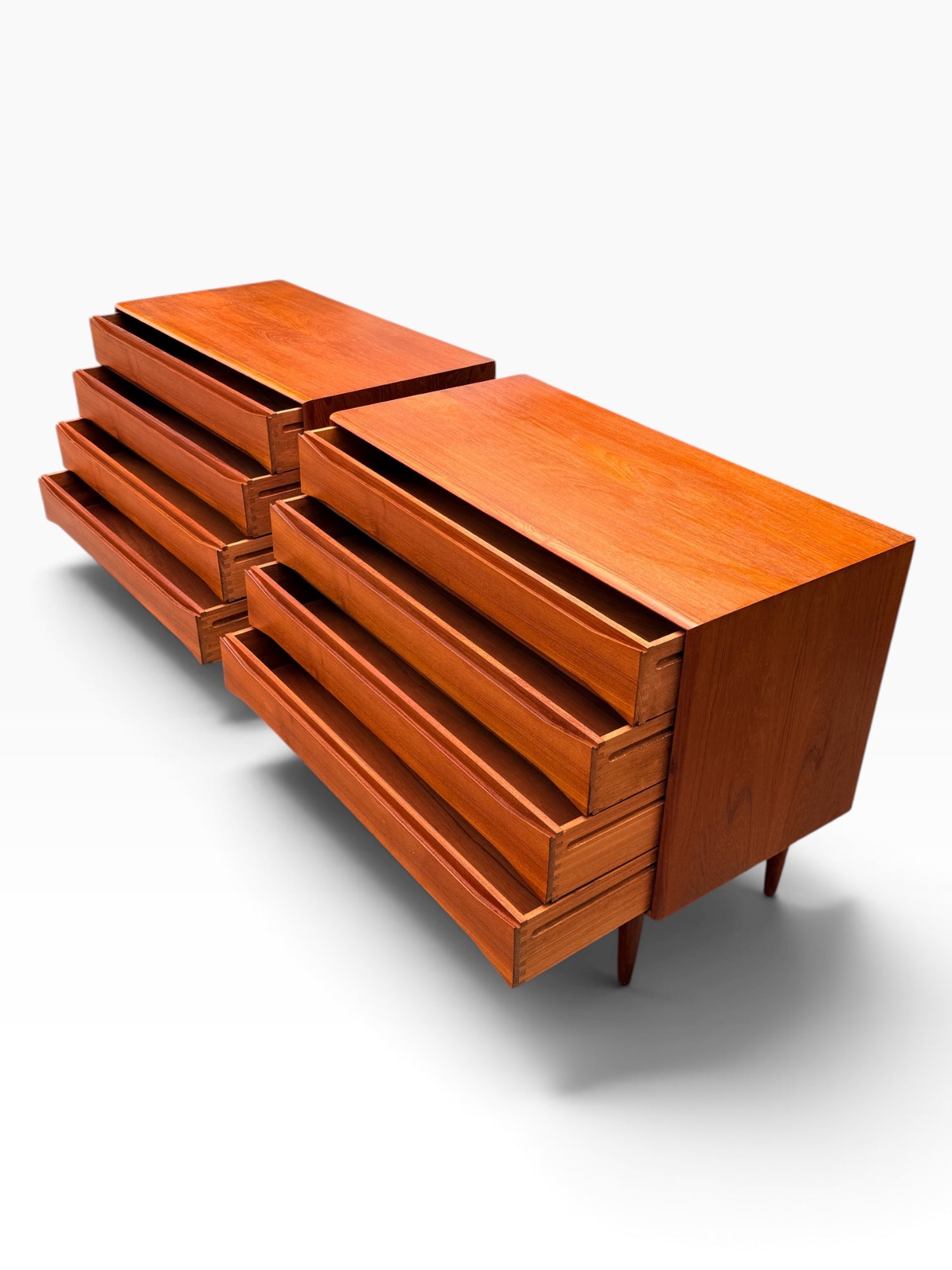 Pair of teak dressers with all drawers extended showing dovetailed boxes