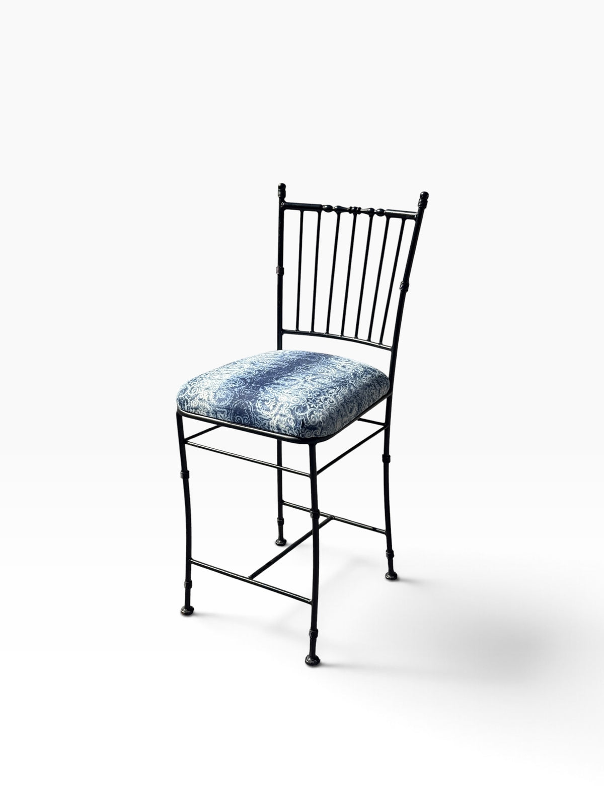 Faux bamboo black wrought iron counter stool with blue and white damask seat, three-quarter view