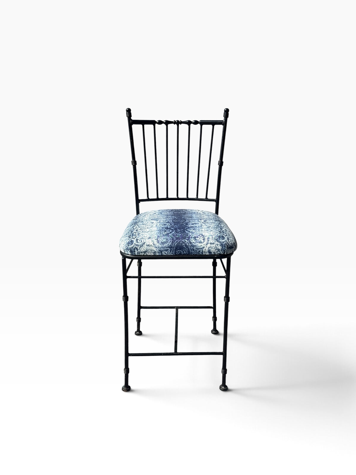 Front view of the wrought iron counter stool showing the spindle back and padded seat