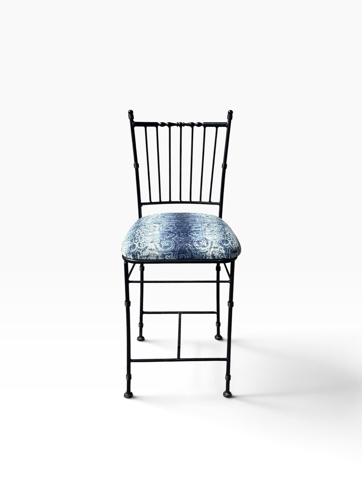 Front view of the wrought iron counter stool showing the spindle back and padded seat
