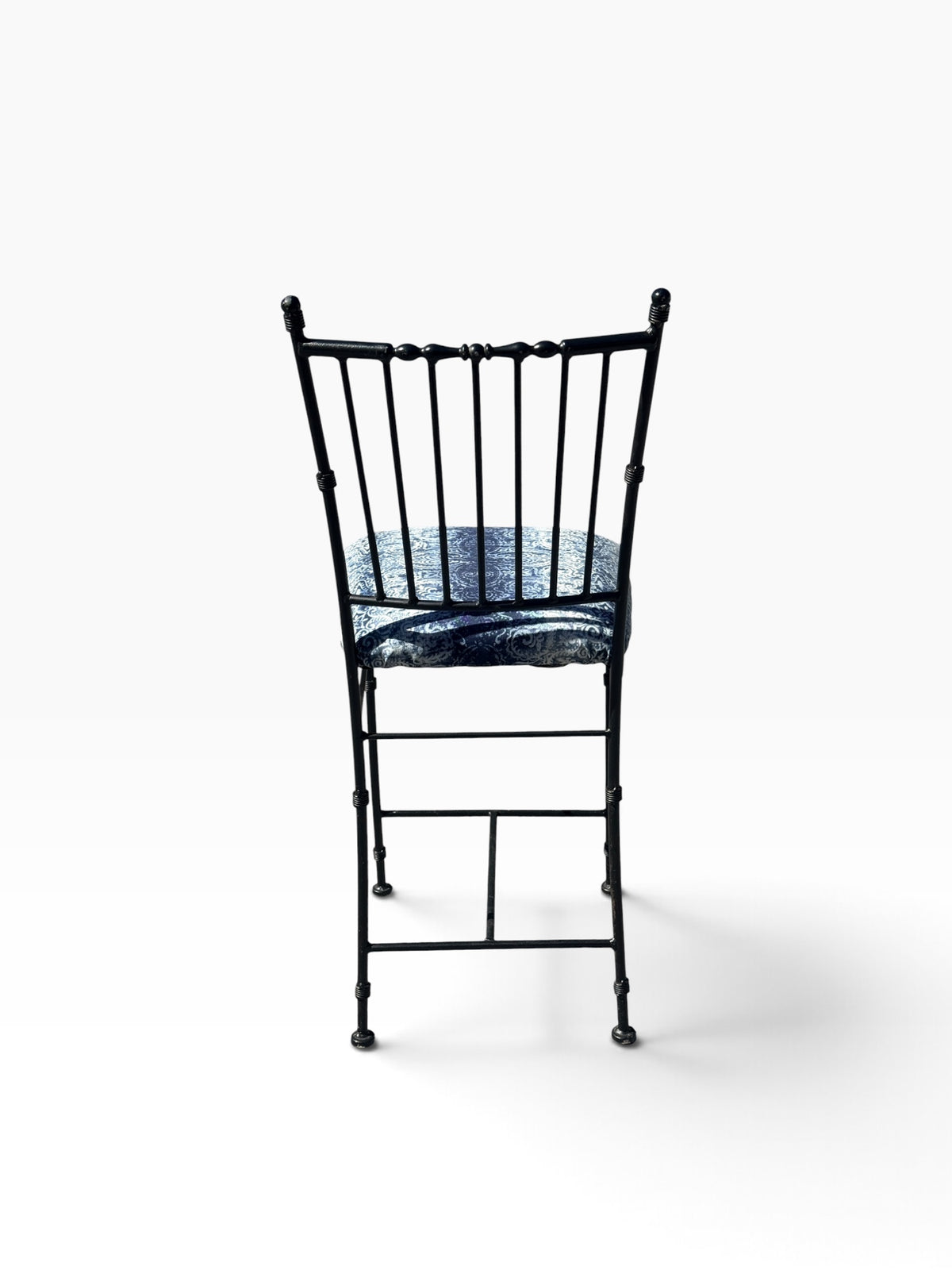 Rear view of the wrought iron counter stool showing the spindle back and H-stretcher