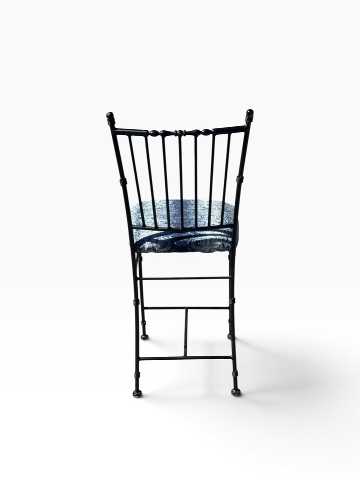 Rear view of the wrought iron counter stool showing the spindle back and H-stretcher