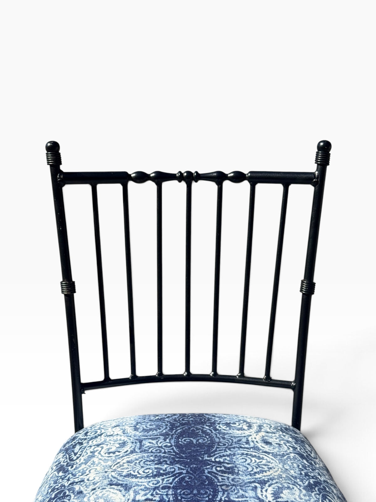 Close view of the turned crest rail and nine back spindles