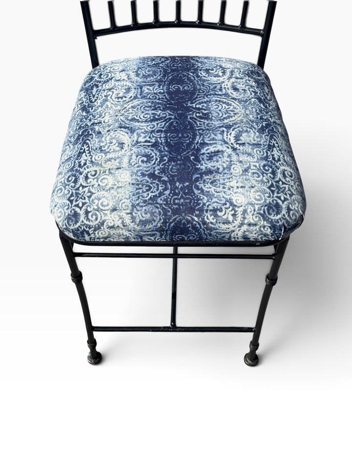 Close view of the blue and white damask print seat and iron frame