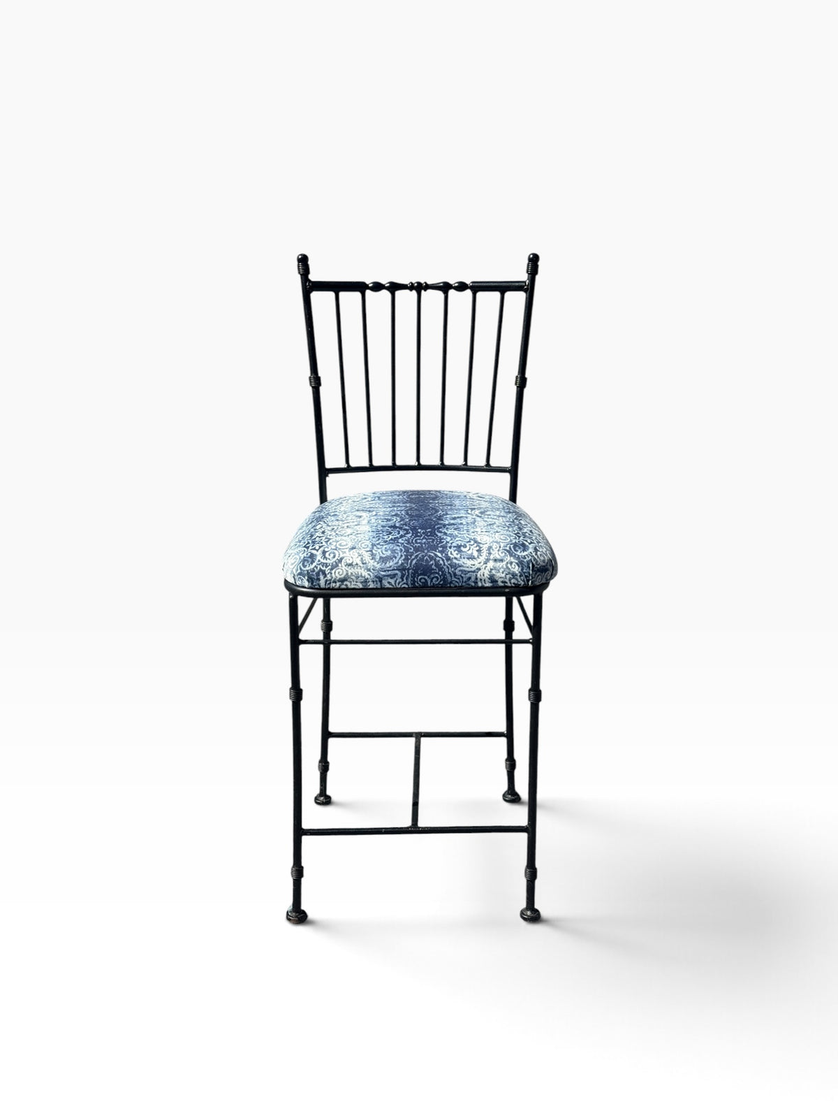 Straight-on front view of the faux bamboo wrought iron counter stool