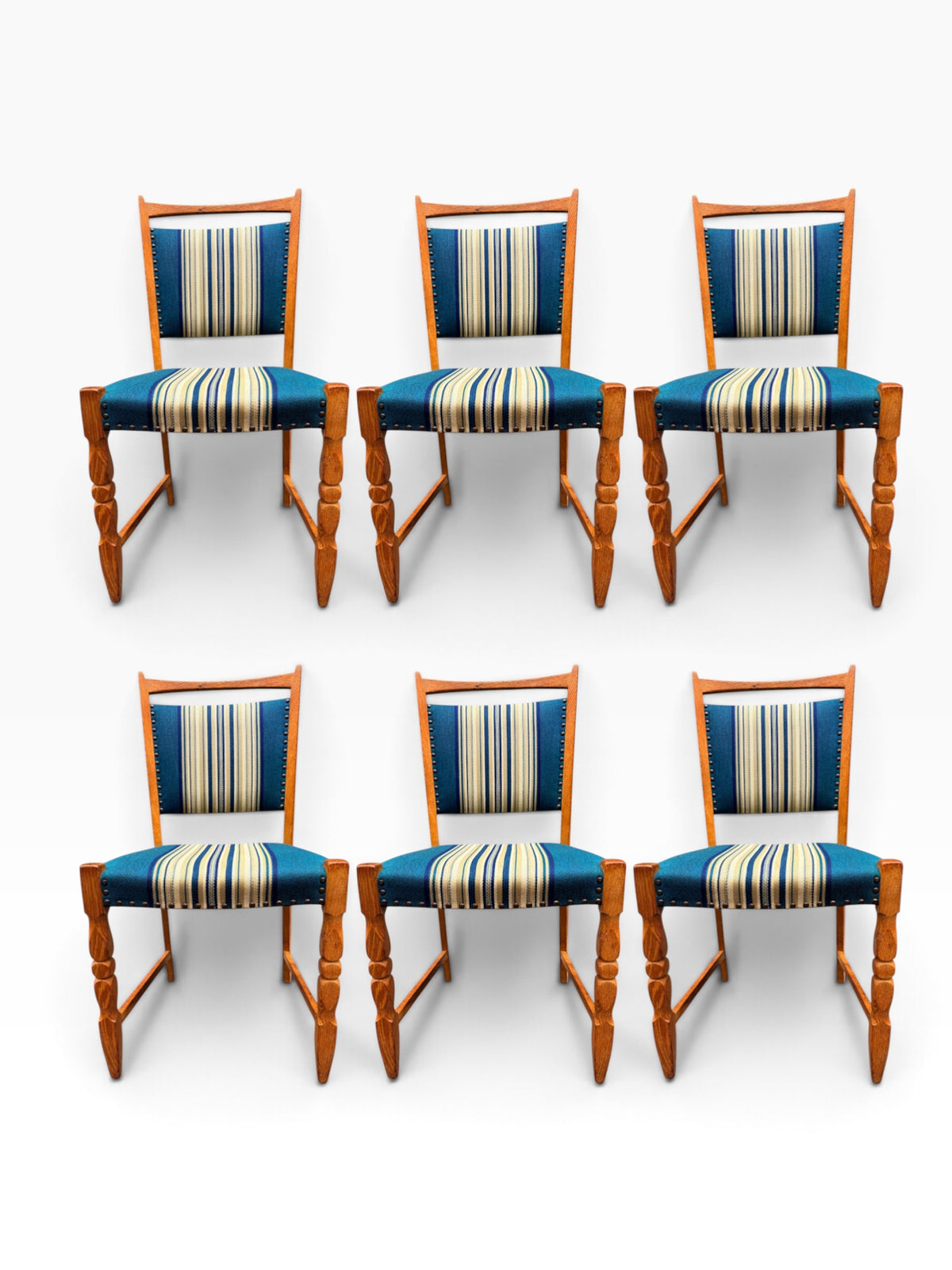 Henning Kjærnulf oak dining chair showing sculpted turned front legs and striped upholstery