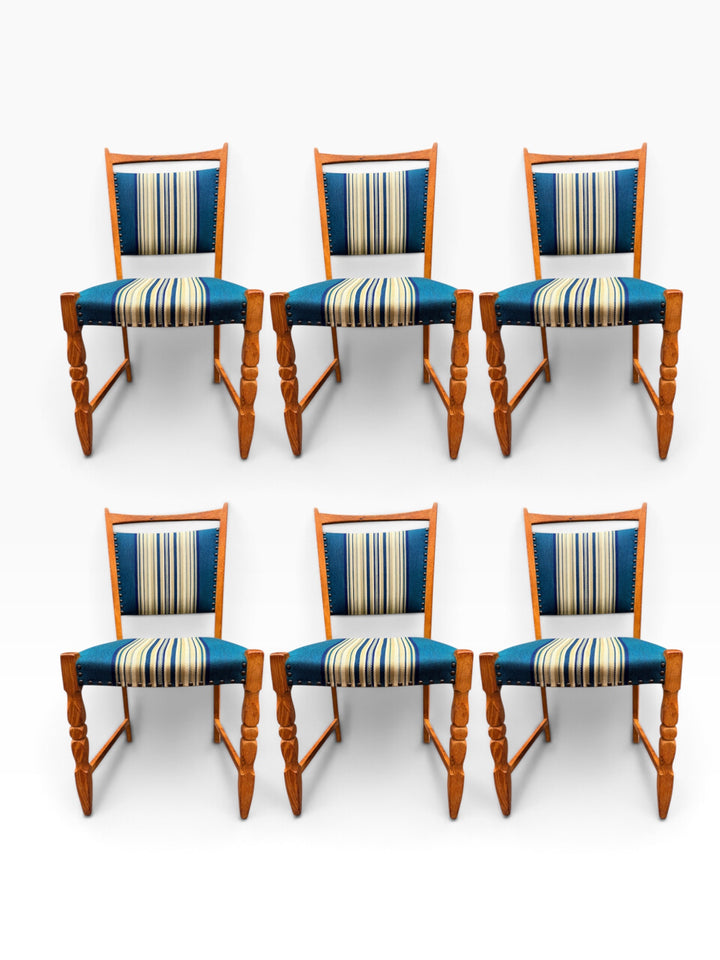 Henning Kjærnulf oak dining chair showing sculpted turned front legs and striped upholstery