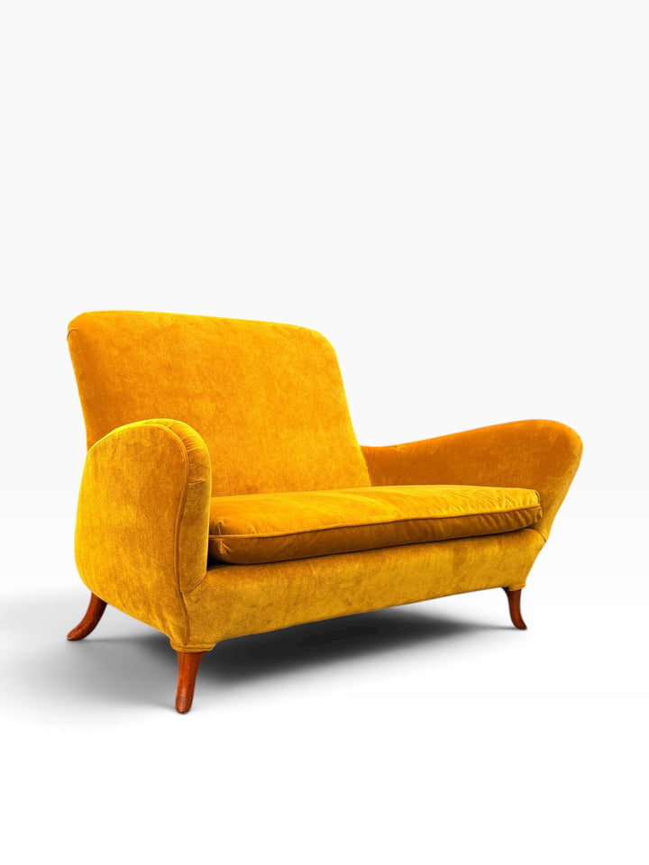 Saffron velvet Italian loveseat, straight-on front view showing curved crest and flared arms