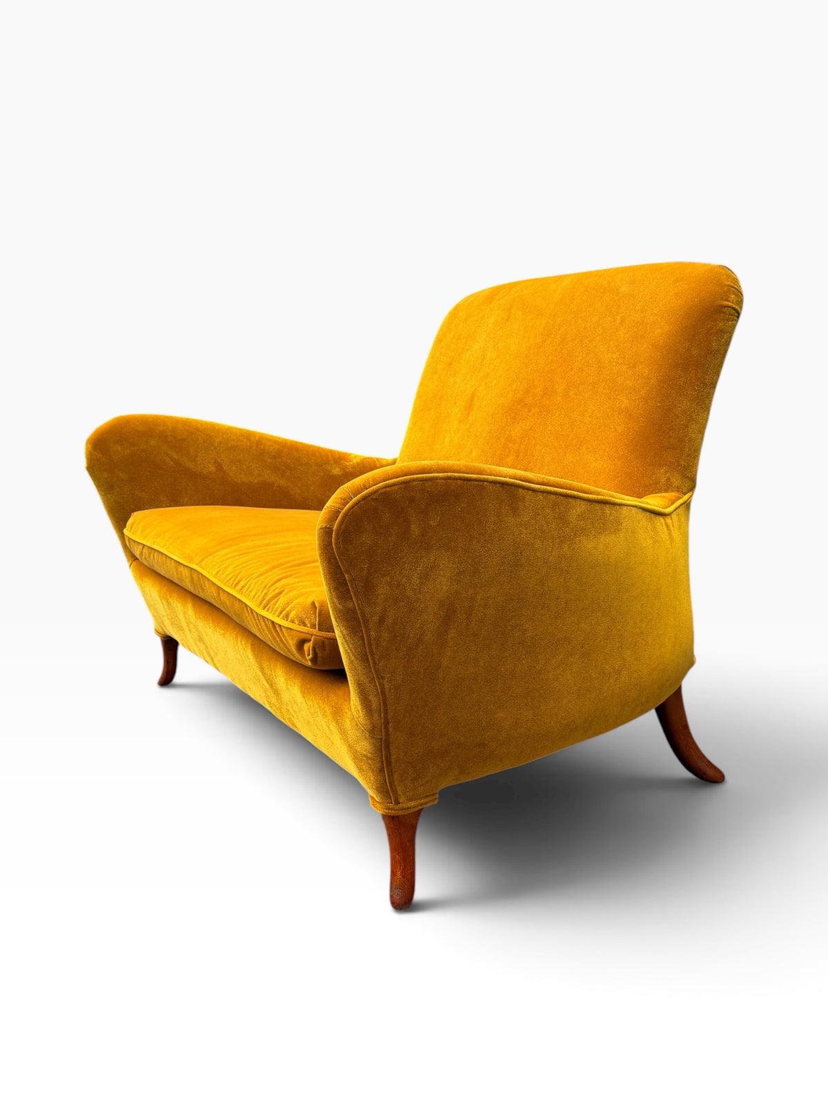 Three-quarter view of the Italian sculptural loveseat showing splayed sabre legs