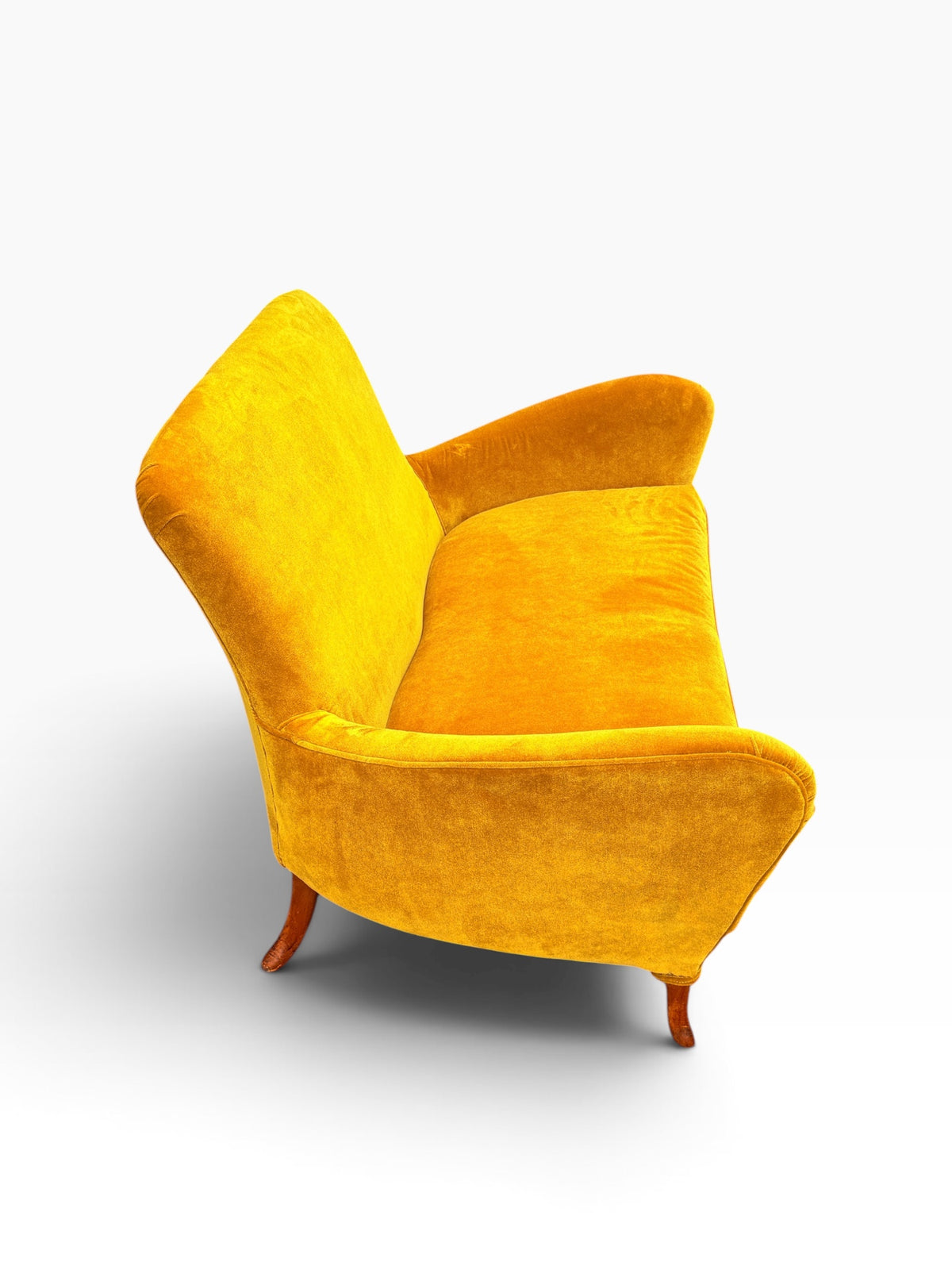 Three-quarter side view of the saffron velvet wing arm loveseat