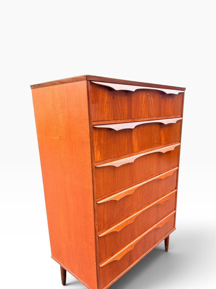 Teak chest of drawers, angled view of sculpted pulls