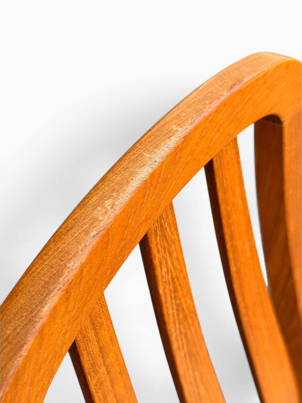 Close-up of curved teak top rail showing light surface wear
