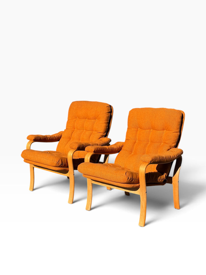 Pair of bentwood lounge armchairs with tufted burnt orange cushions