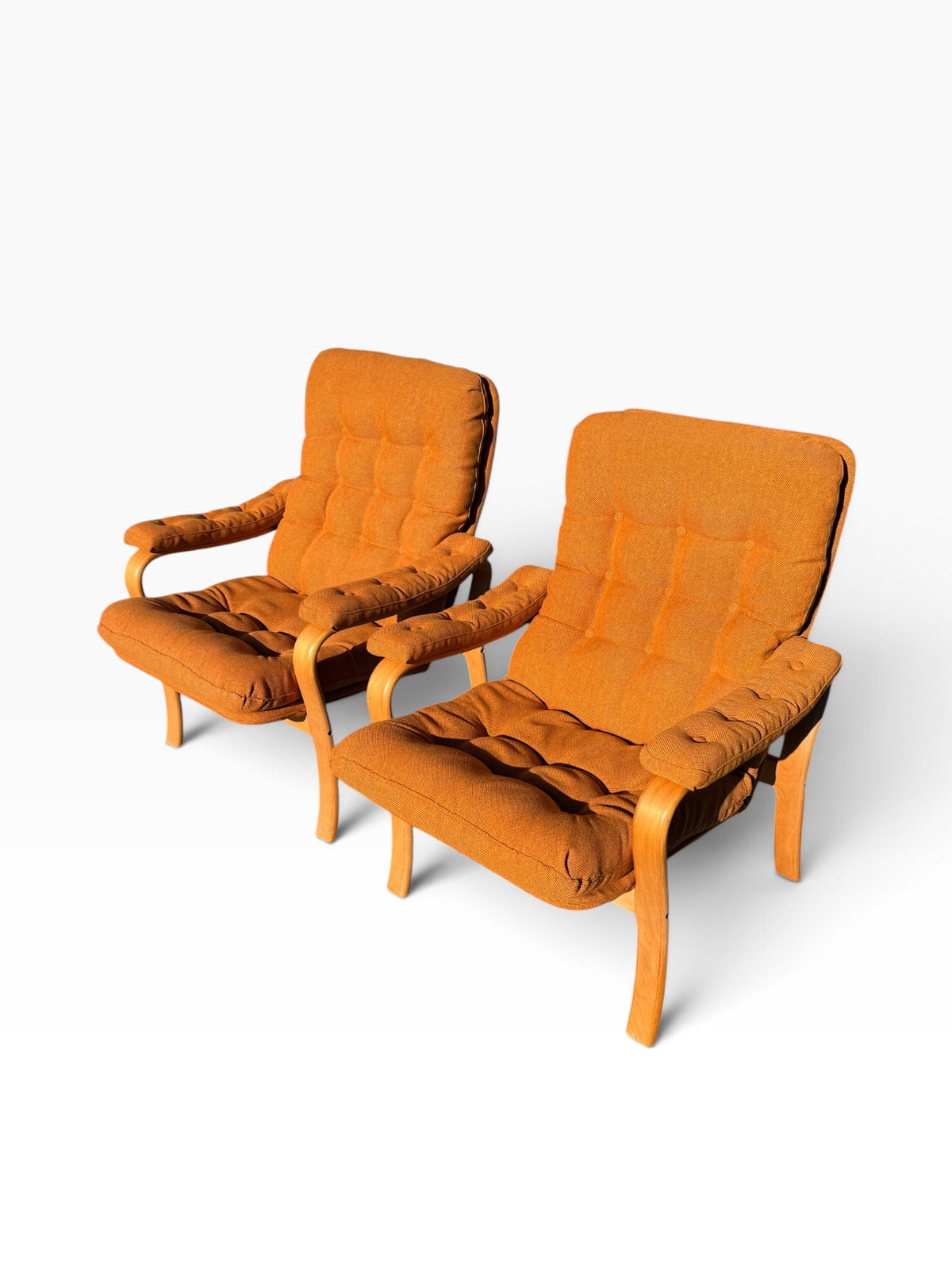 Pair of bentwood armchairs from above showing tufted seats and backs