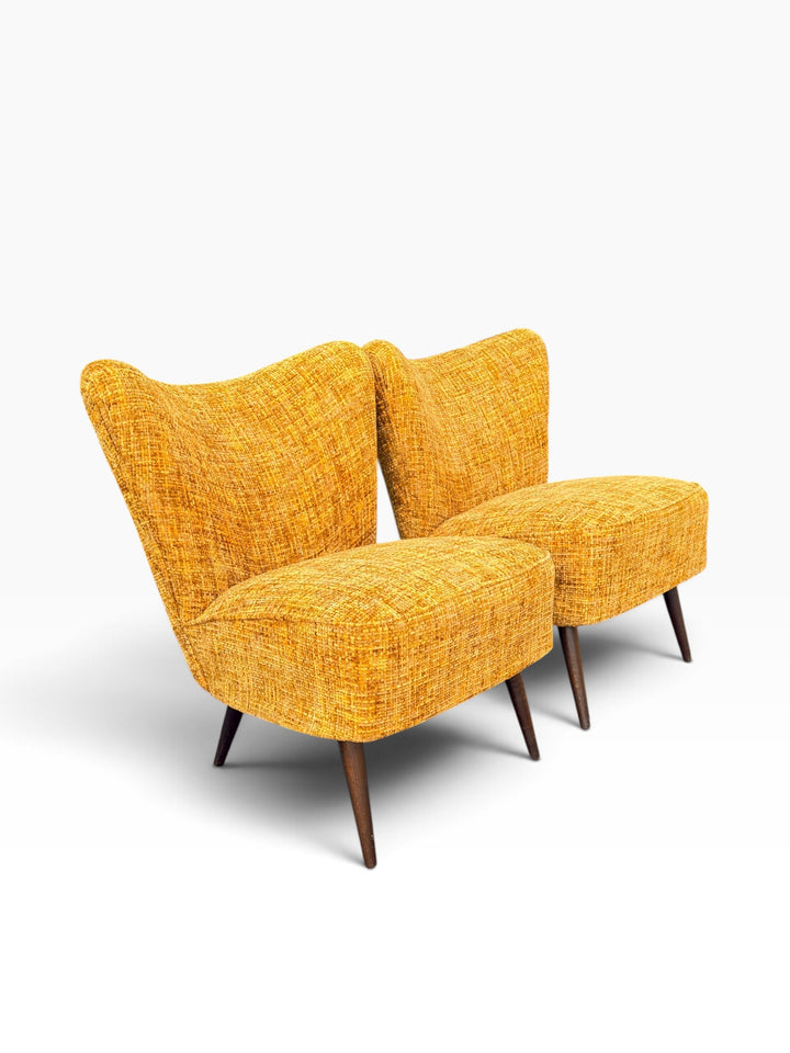 Pair of mustard tweed cocktail chairs on tapered legs, three-quarter view