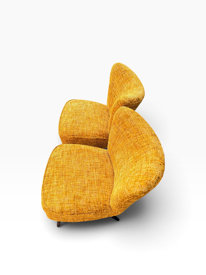 Pair of cocktail chairs showing curved winged backs