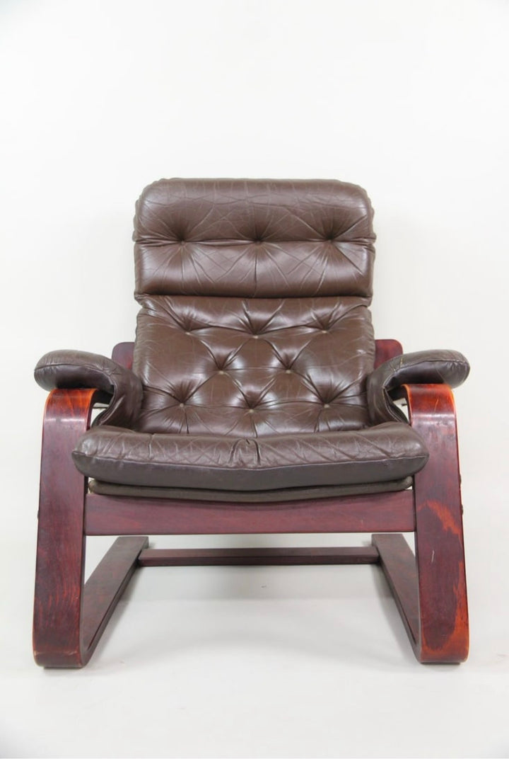 Front view showing the diamond-tufted back, headrest and padded leather arm pads
