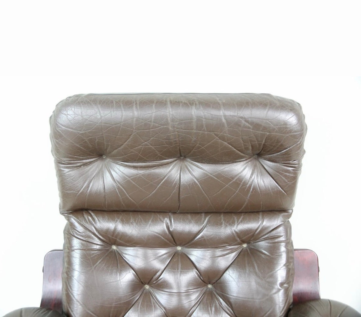 Close detail of the buttoned leather headrest and tufted back