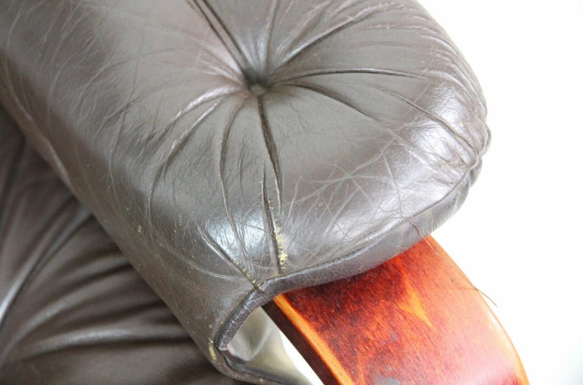 Close detail of a leather arm pad showing patina and seam wear