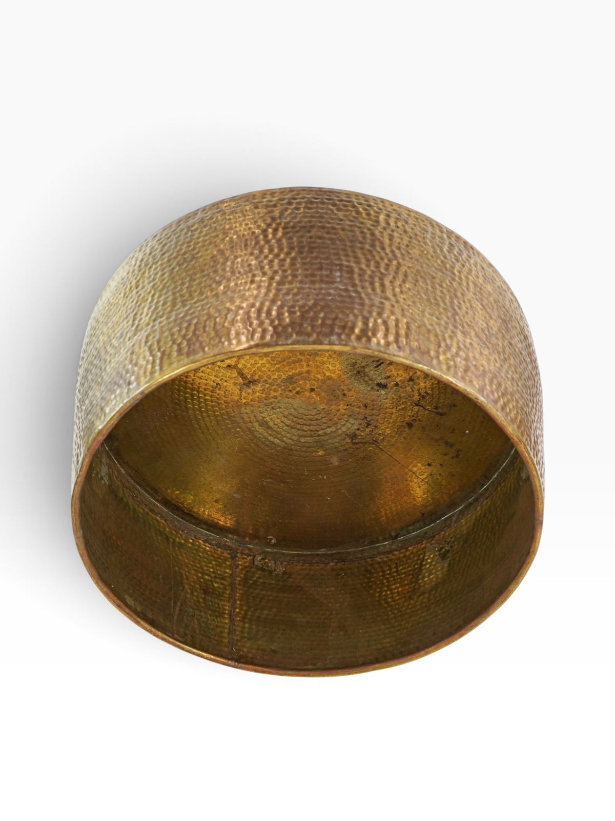 Underside of the hammered brass drum coffee table showing the open interior