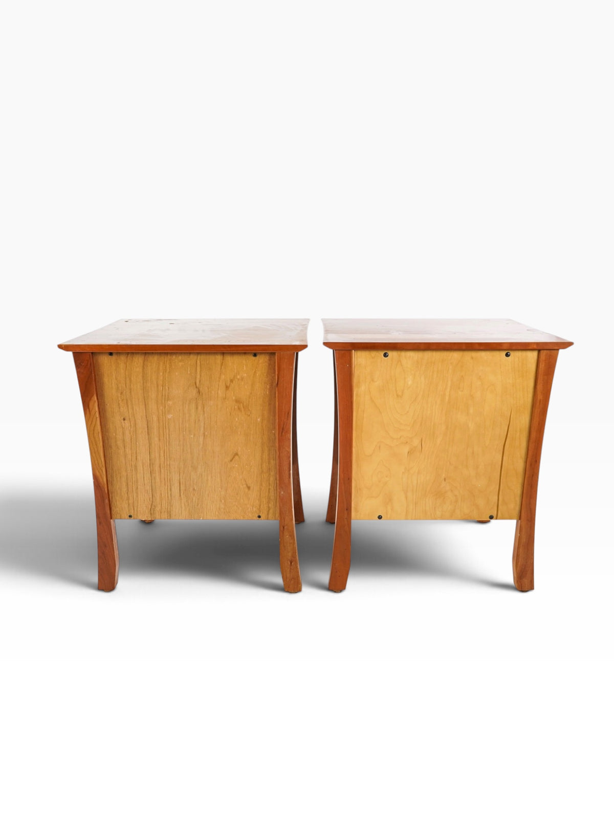 Rear view of the pair of cherry bedside tables showing panelled backs and flared legs