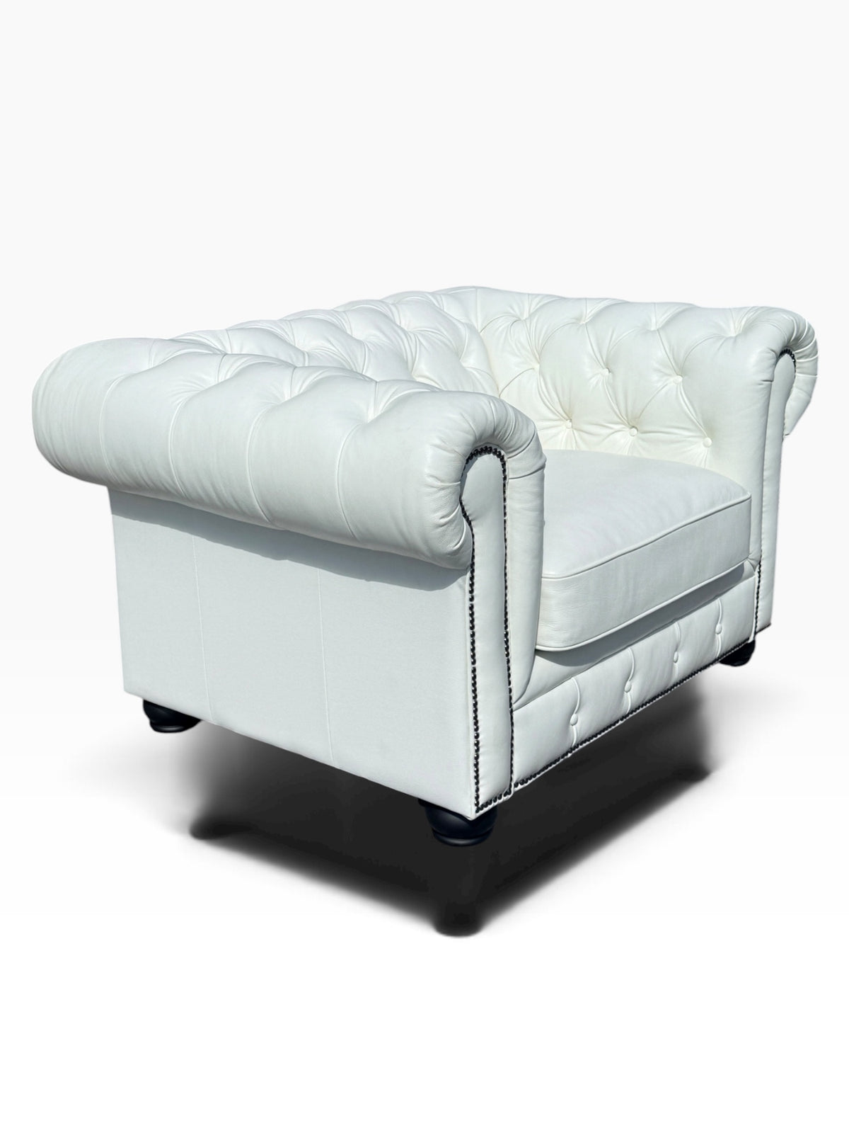 Rear three-quarter view of tufted white leather club chair with bun feet