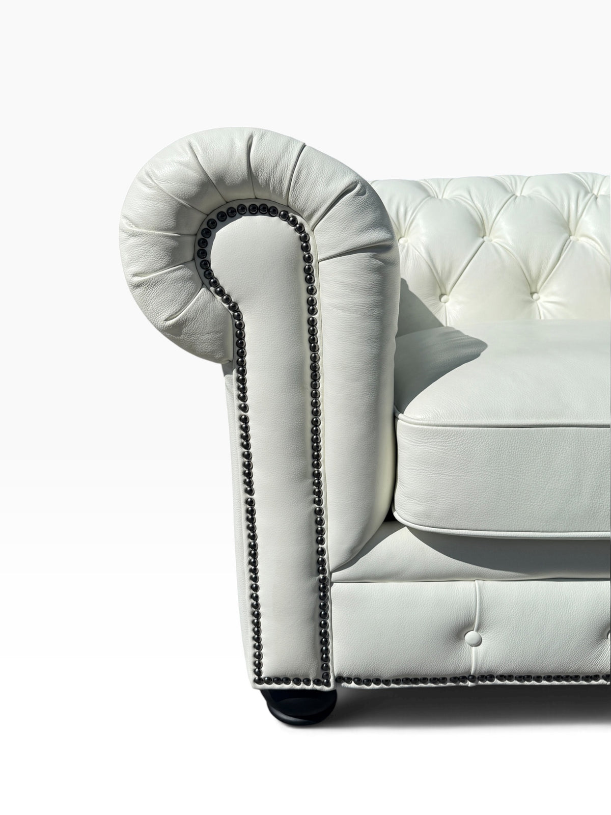 Detail of scrolled arm, button tufting and nailhead trim