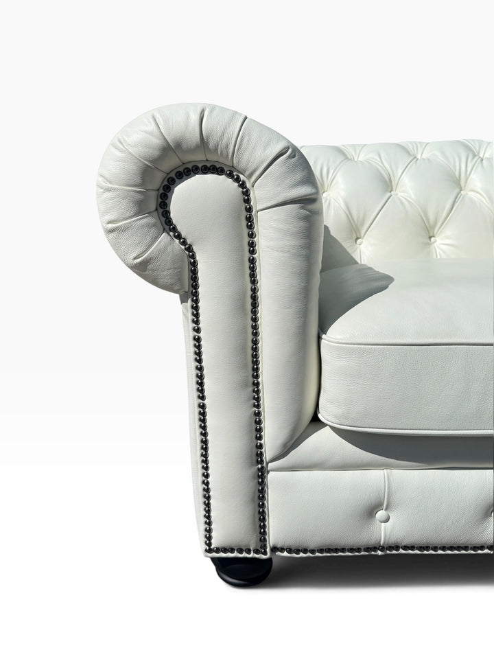 Detail of scrolled arm, button tufting and nailhead trim