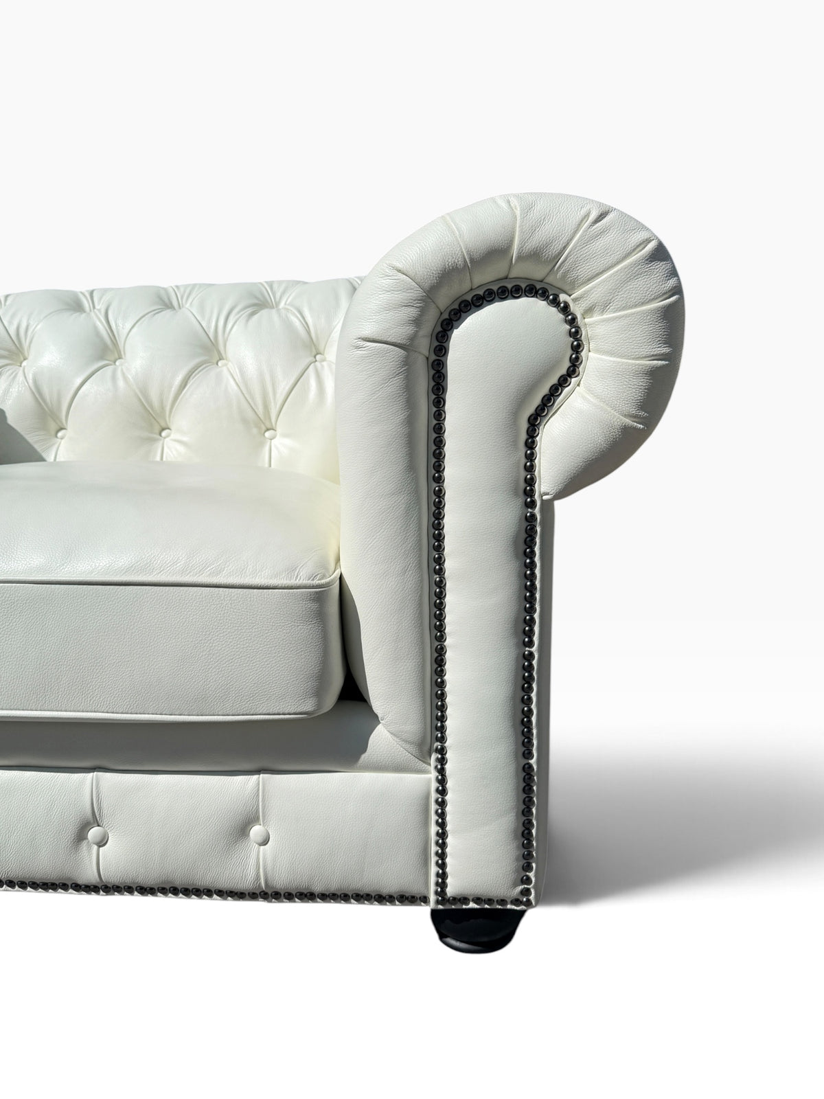 Detail of opposite arm roll, nailhead trim and ebonized bun foot