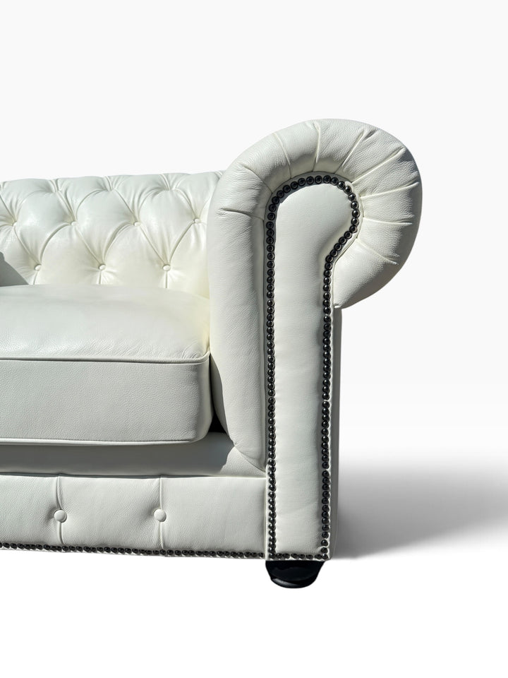 Detail of opposite arm roll, nailhead trim and ebonized bun foot