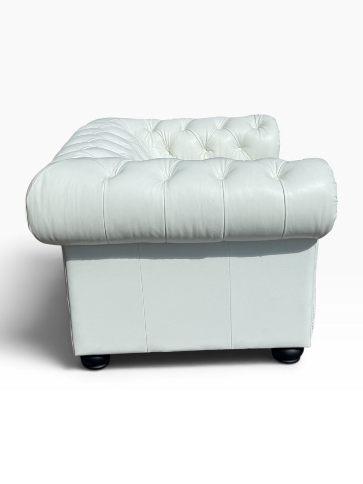 Back view of white leather Chesterfield chair showing tufted back and side panel